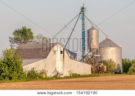 Rust barn and silos in agriculture farmland.
