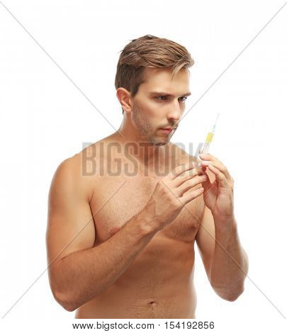 Muscular man holding syringe on white background