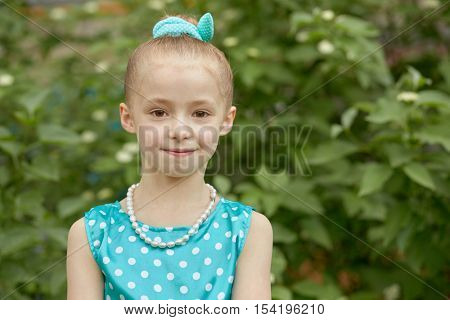 Portrait of smiling little girl dressed in polka-dotted gown.