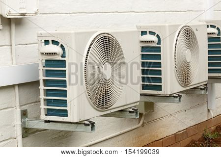 Weathered White Airconditioning Units Mounted On Exterior Home Wall