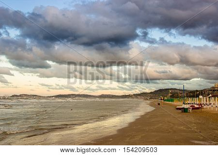 Beautiful dramatic cloudscape over the sea at sunset. Warm filter used. Falconara Italy