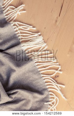 warm wool throw plaid on wooden background