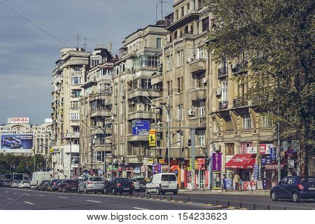 Bucharest Romania - April 22 2014: Urban scene with apartment blocks with kiosks groceries shops at ground floor in the old central residential district along the busy Corneliu Coposu boulevard.