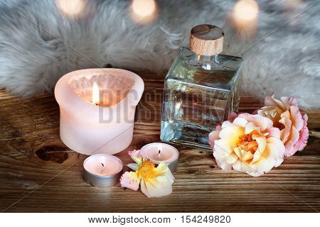 Spa decoration with aromatic oil and candle on a wooden table with lambskin