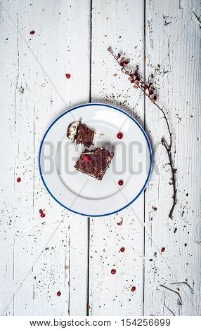 Chocolate cake with cream and fruit on retro wooden table