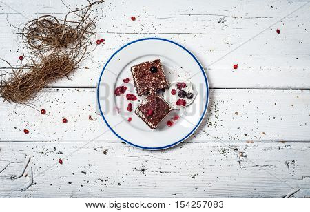 Chocolate cake with cream and fruit on retro wooden table