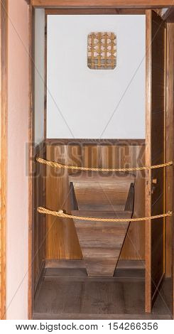 Takayama Japan - September 24 2016: This historic wooden Japanese urinal for the government bureaucrats and judges can be found in the Takayama Jinya hall. Brown wood white wall.
