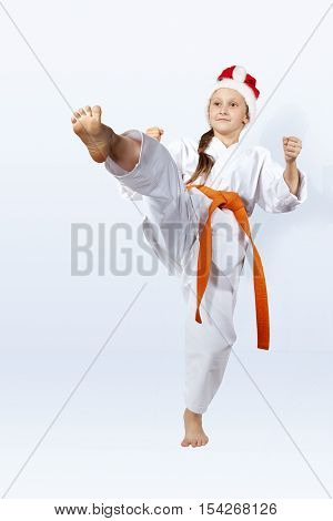 With orange belt girl in the cap of Santa Claus strikes a blow