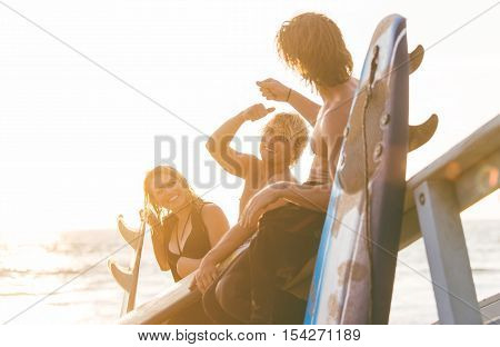 Group of surfers chilling out on the beach. sitting on the lifeguard house and having fun