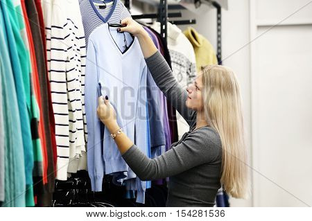 Woman in the clothing shop. Girl in clothes store