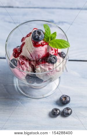 Bowl with blueberry ice cream on wooden table
