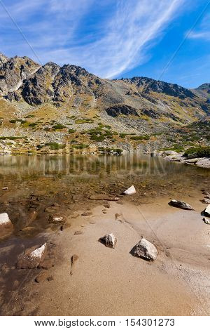 Beautiful Pleso nad Skokom in Mlynicka dolina on the way to Bystre sedlo - in slovakian high Tatra mountains. Summer panorama with great weather and blue sky