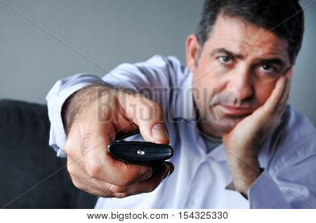 Upset And Bored Man Holding Tv Remote Control Zapping Tv Channels