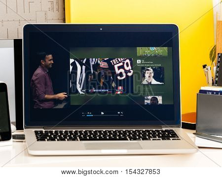 PARIS FRANCE - OCT 28 2016: Apple Computers website on new MacBook Pro Retina with OLED Touch bar in geek creative room showcasing Apple Keynote presentation of Tv app by Apple Nfl game