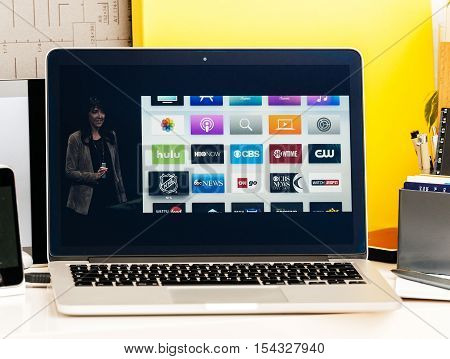 PARIS FRANCE - OCT 28 2016: Apple Computers website on new MacBook Pro Retina with OLED Touch bar in geek creative room showcasing Apple Keynote presentation of Apple tv Watch now TV app channels movies and shows