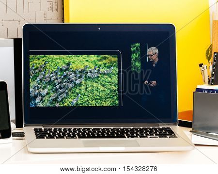 PARIS FRANCE - OCT 28 2016: Apple Computers website on new MacBook Pro Retina with OLED Touch bar in geek creative room showcasing Apple Keynote Tim Cook talking about the MacBook Pro and its advantages