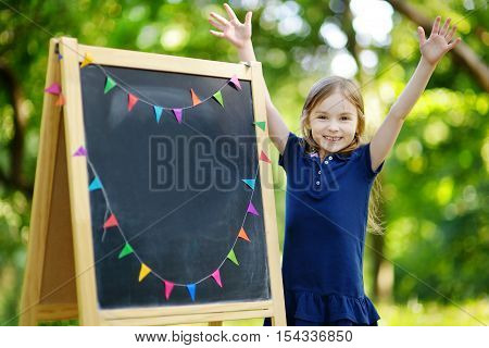 Very Excited Little Schoolgirl By A Chalkboard