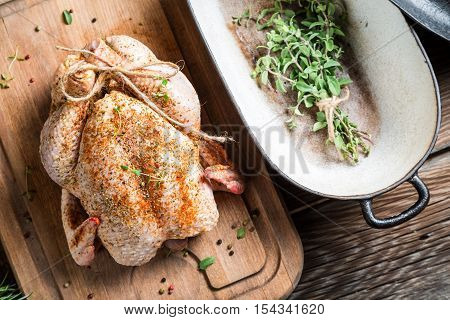 Spiced chicken before roasting on wooden table