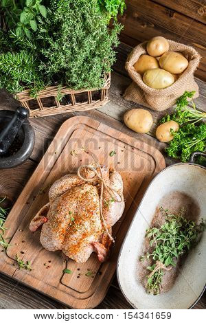 Roast chicken with herbs and vegetables on wooden table