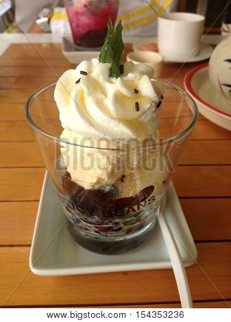 Cold vanilla icecream with red bean on wooden table