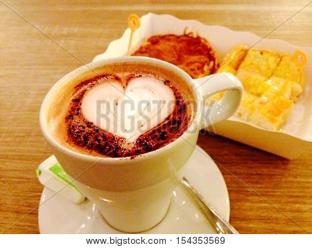 Hot cocoa and sweet bread on wooden table