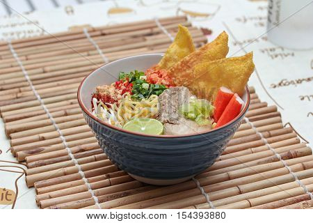 Close up of Japanese noodle (ramen) in spicy sour soup as "tom yam " in pork's bone soup. Selective focus.