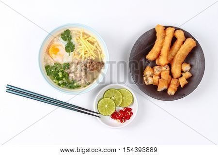 Rice porridge with mined pork and chicken lever served with side dish as Patongko (deep-fried dough stick) and spicy sour filling.