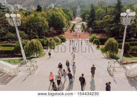 TBILISI, GEORGIA - OCT 16, 2016: People walking in green Vake public park with high trees alley at sunny day on October 16, 2016. Tbilisi has a population of 1.5 million people