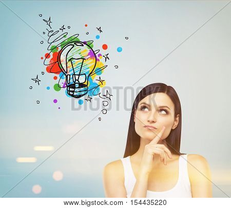 Girl In Tank Top Looking At Light Bulb On Blue Wall, Toned