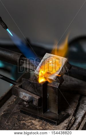 Close-up of Silver Casting from Crucible to Metal Mold with blowtorch; Goldsmith Workshop;