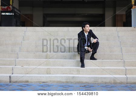 Portrait Of A Smiling Young Handsome Businessman Sitting On The Stairs