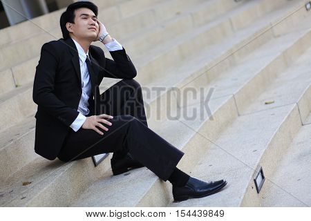 Portrait Of A Smiling Young Handsome Businessman Sitting On The Stairs
