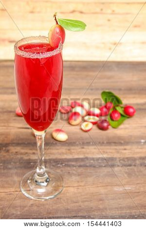 Carandas-plum  juice  in a glass on wooden background