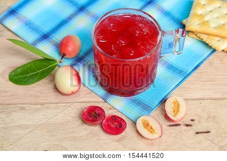 Carandas-plum  juice  in a glass on wooden background