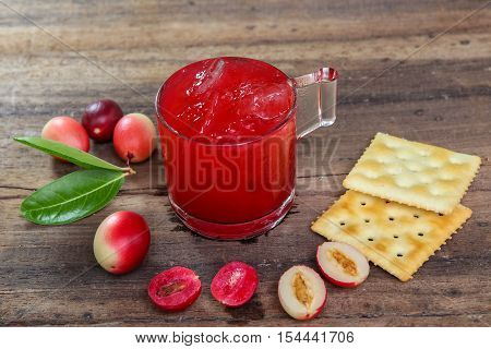Carandas-plum  juice  in a glass on wooden background