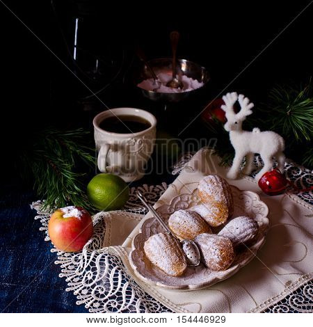 Homemade biscuits madeleines with powdered sugar on a dark background. Selective focus.