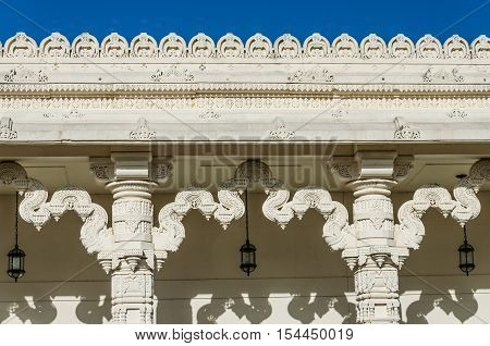 Detailed ornament on the wall of a Hindu temple with columns.