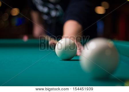 Russian billiards game in progress: player aims to shoot balls with cue