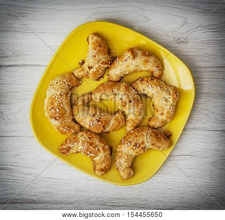 Tasty pastries on the yellow plate. Food theme. Crispy pastry. Sesame snacks.