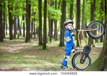 Happy Kid Boy Of 4 Years Having Fun In Autumn Or Summer Forest With A Bicycle