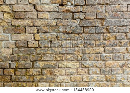 Brick wall. Brick wall. Brick wall with bricks of different sizes and shapes of gray color with addition of sand color.