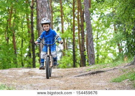 Happy Funny Little Kid Boy In Colorful Raincoat Riding His First Bike On Cold Day In Forest. Active