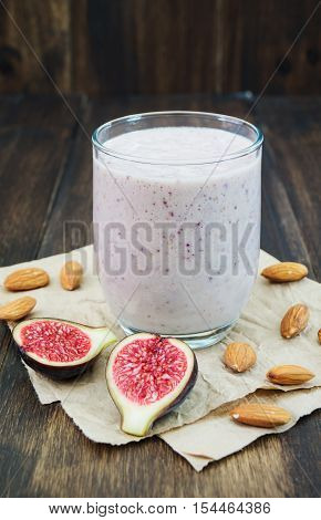 Honey almond fig smoothie. Healthy autumn fall smoothie on wooden background vertical selective focus