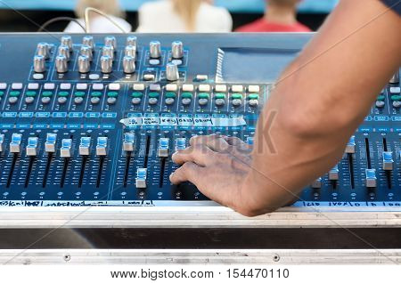 Sound technician adjusts the sound in professional equipment.