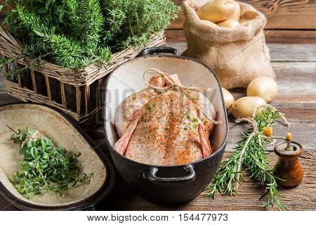 Closeup of raw chicken with herbs in casserole dish