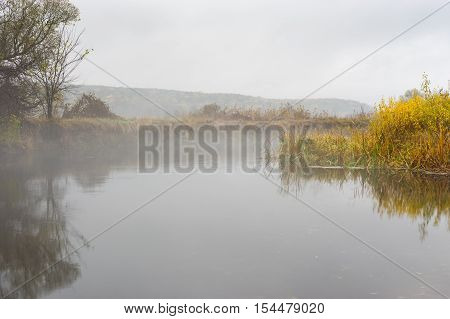 Autumnal landscape with foggy Vorskla river at autumnal season in Sumskaya oblast Ukraine