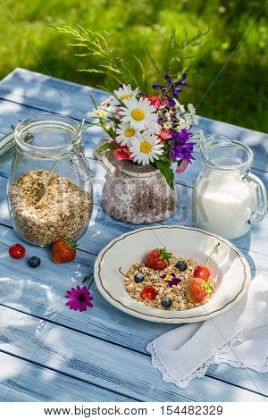 Breakfast with oatmeal fruit and milk on old wooden table