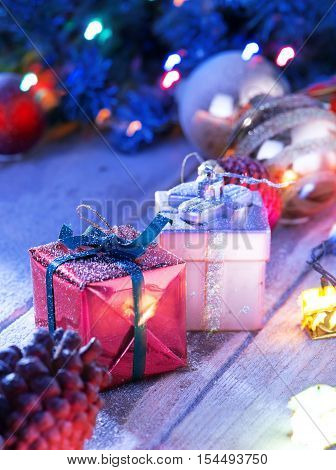 close up view  of lights and gift box on snowbound  wooden back