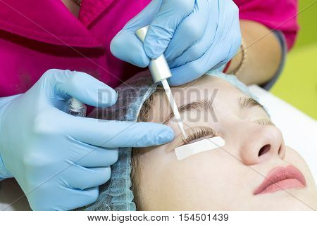 Woman on the procedure for eyelash extensions, eyelashes lamination