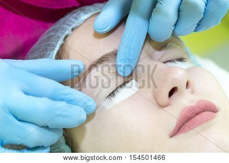 Woman on the procedure for eyelash extensions, eyelashes lamination